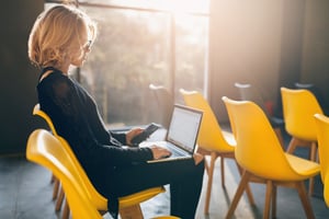 young-pretty-busy-woman-sitting-alone-conference-room-many-yellow-chairs